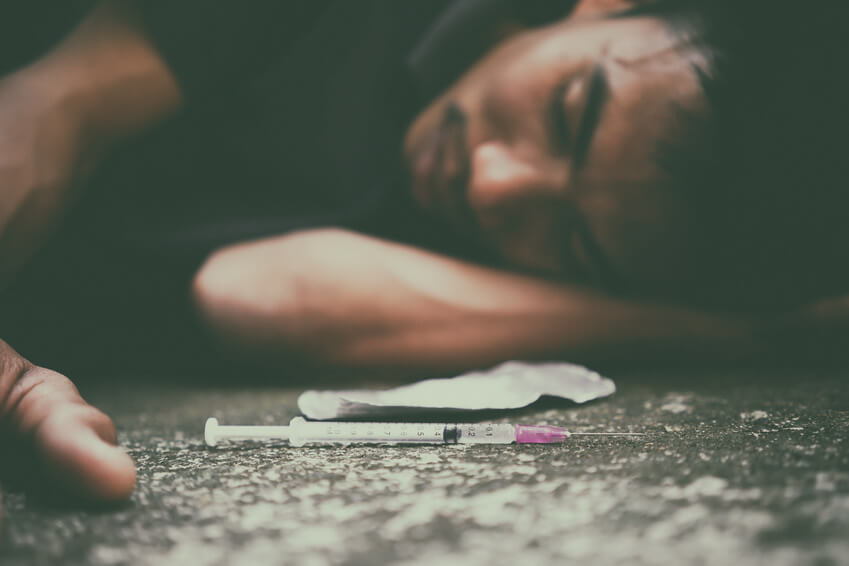 Phoenix man lying on ground after heroin overdose seeking a Christian drug rehab in Gilbert AZ