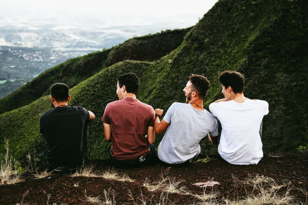 young men who are former drug addicts in Christian aftercare program laughing while taking a break during a hike