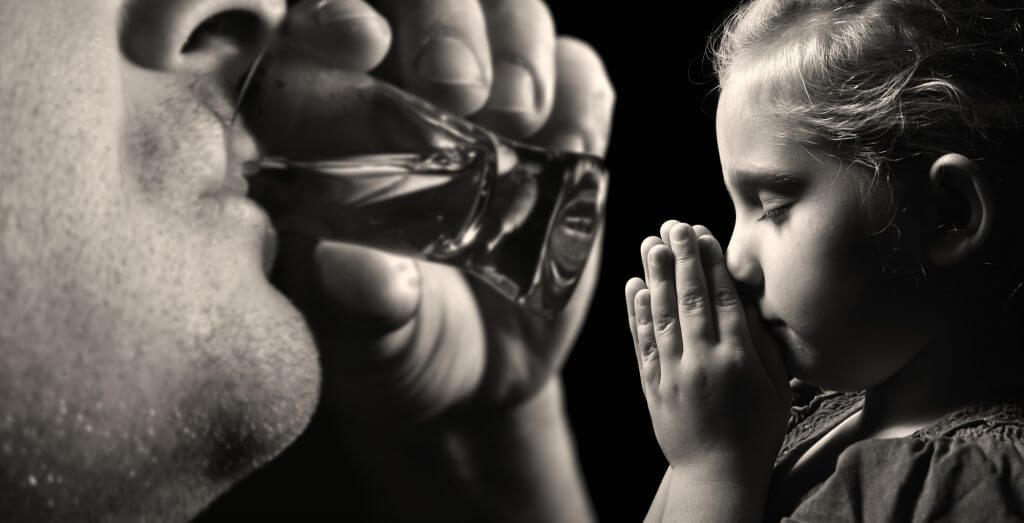 boy praying for alcoholic dad drinking vodka who wants him to have a Christian addiction treatment center in arizona